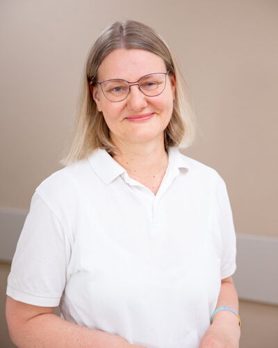 Dr. med. Kathrin Scheibner, Fachärztin für Innere Medizin und Nephrologie, steht vor einer ruhigen Wandfläche. Ihr freundlicher Blick und die schlichte Kleidung unterstreichen ihre medizinische Professionalität.